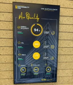 A digital display shows air quality metrics for One Bartholomew, including overall air quality at 94%, CO2 at 500 ppm, PM2.5 at 1.72, humidity at 38%, temperature at 20.4°C, and VOC at 39. The display also shows the date & time
