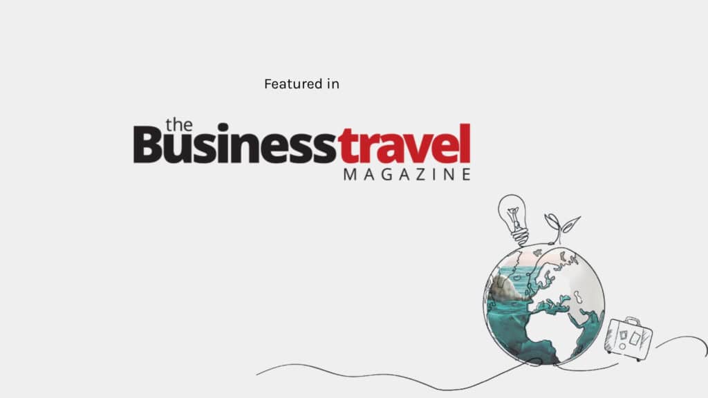 The Business Travel Magazine logo, with 'Business' in black and 'travel' in red, and 'MAGAZINE' below, alongside a sketched globe with a lightbulb and sprouting plant on top, and a suitcase beside it, symbolising travel and sustainability.
