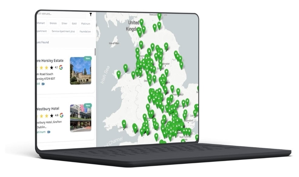 Laptop with a map of the United Kingdom showing many green location pins, alongside a sidebar with listing cards and text on a white interface.